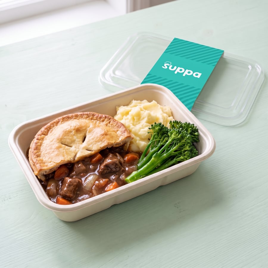 Beef and ale pie in an open Suppa tray, with its clear lid and teal sleeve set beside it