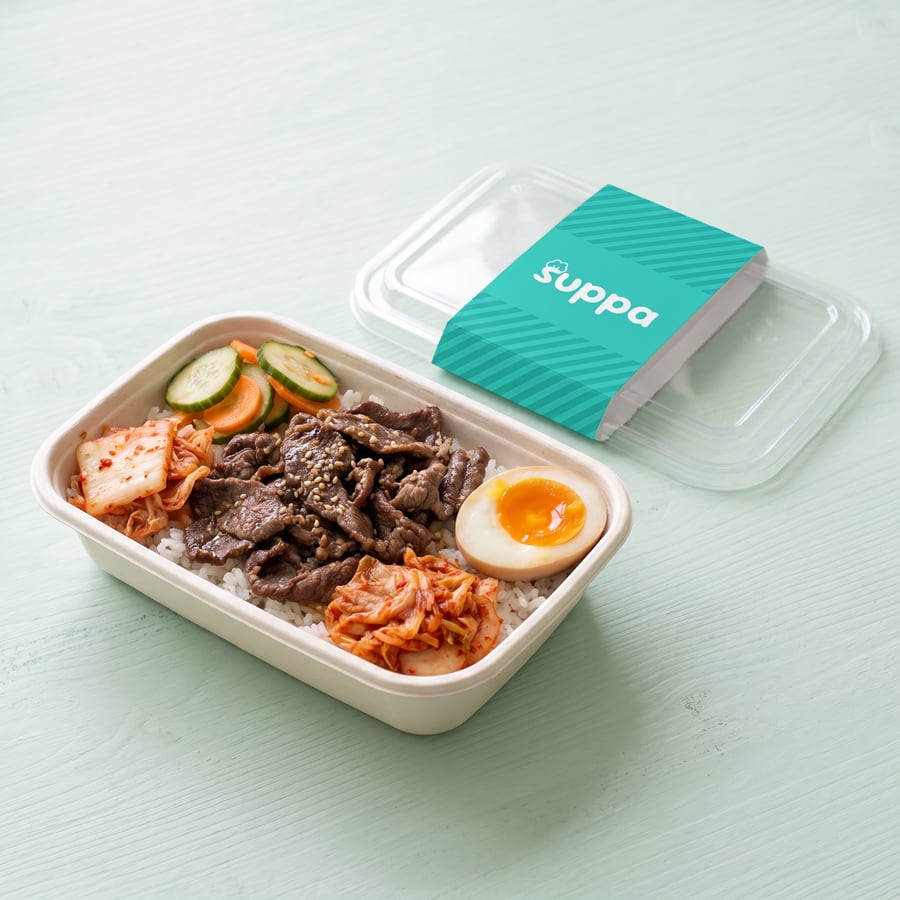 Korean beef bulgogi bowl in an open Suppa tray, with its clear lid and teal sleeve set beside it