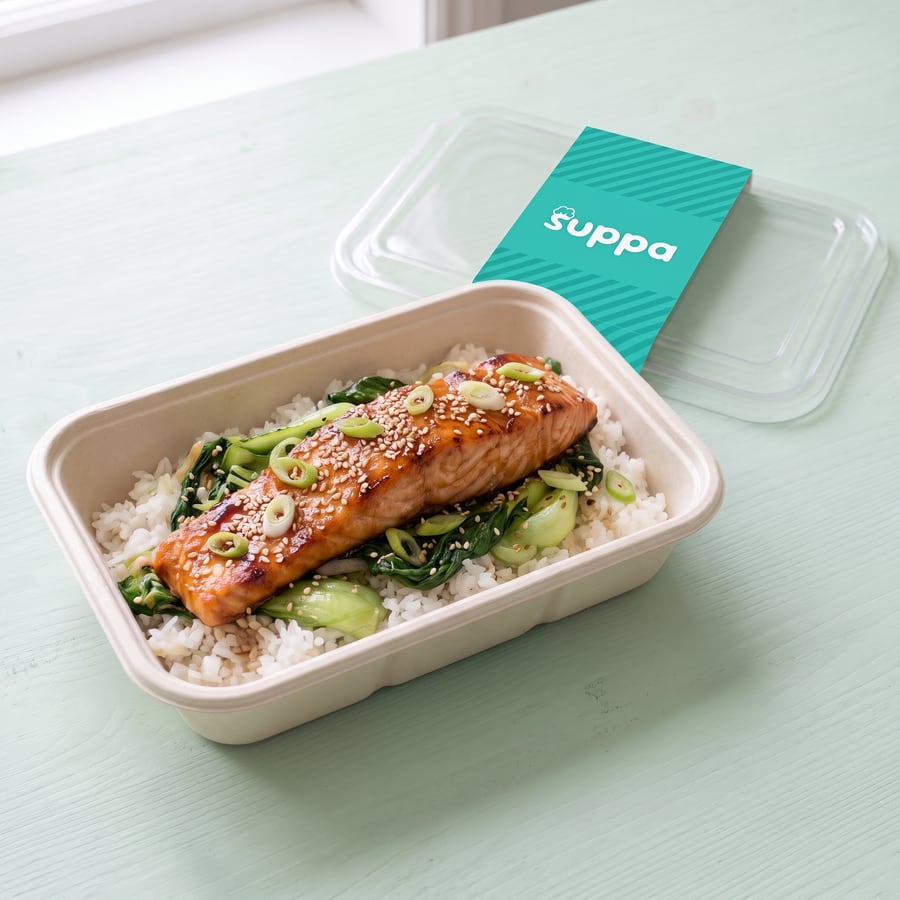 Teriyaki salmon in an open Suppa tray, with its clear lid and teal sleeve set beside it