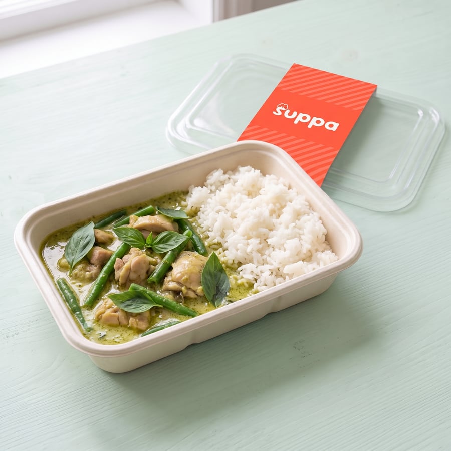 Thai green chicken curry in an open Suppa tray, with its clear lid and coral sleeve set beside it
