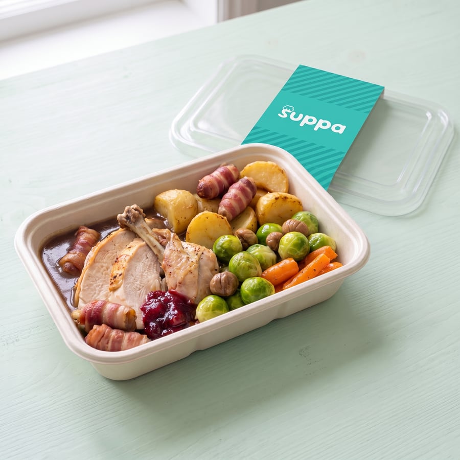 The Full Christmas in an open Suppa tray, with its clear lid and teal sleeve set beside it