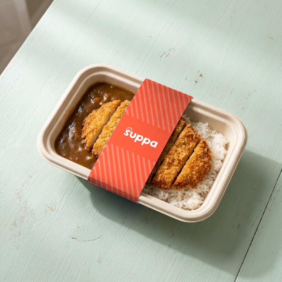 Chicken katsu curry packed in a Suppa tray with a orange striped sleeve