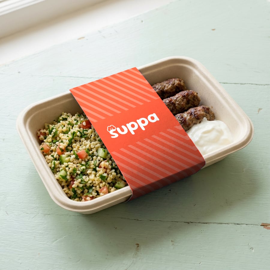 Lamb kofta with tabbouleh packed in a Suppa tray with a orange striped sleeve