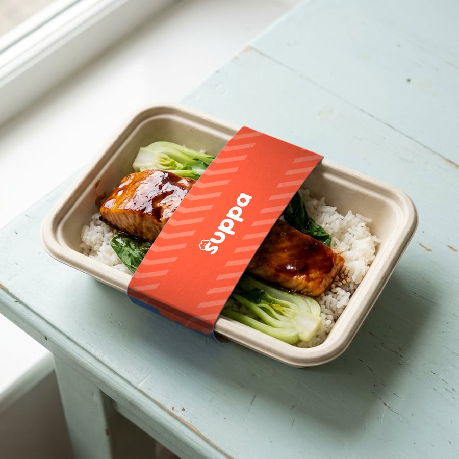 Teriyaki salmon packed in a Suppa tray with a orange striped sleeve