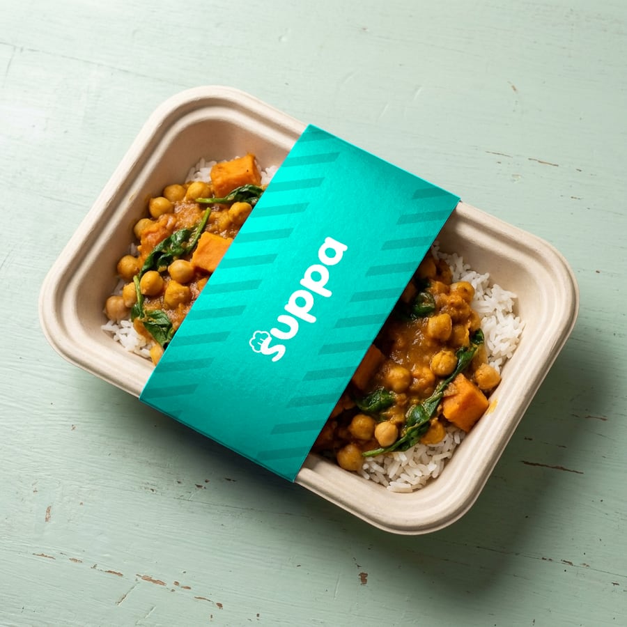 Chickpea and sweet potato curry packed in a Suppa tray with a teal striped sleeve