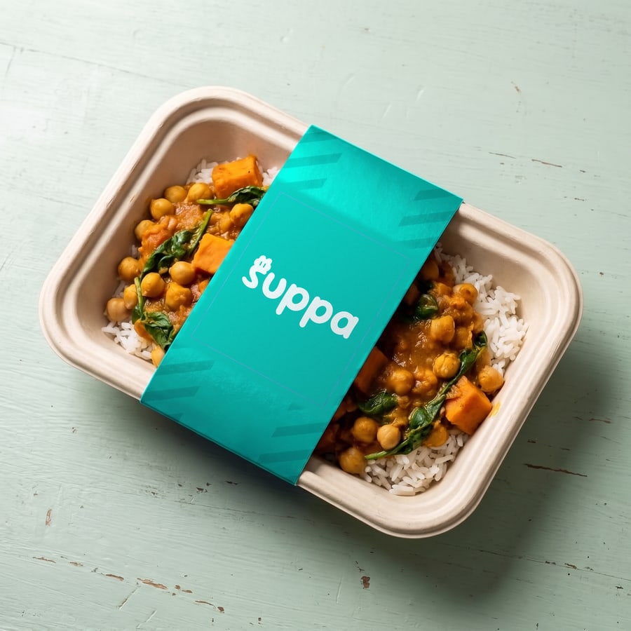 Chickpea and sweet potato curry packed in a Suppa tray with a teal striped sleeve